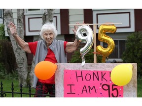 Spunky senior Edna Cretney, 95, salutes her friends who dropped by outside to ensure physical distancing on her birthday in Forest Glade on May 19, 2020.