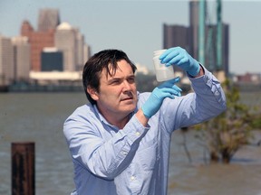 Mike McKay, executive director at Great Lakes Institute for Environmental Research, is shown taking an effluent water samples from the Detroit River in this 2020 file photo.  McKay and his University of Windsor team are studying sewage wastes to monitor COVID-19.