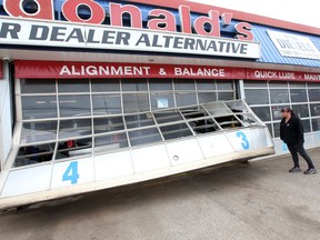 Windsor, Ontario. May 5, 2020. Laura Hebert of Macdonald's Automotive on Eugenie Street checks damage to a $6000 garage door following a break and enter and theft Tuesday.  Windsor Police were called after a suspect broke into the automotive repair garage and came crashing through a large garage door driving a 2006 Dodge Charger.  The operators of Macdonald's have video of the crazy incident. See story.