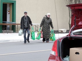 Windsor, Ontario. May 5, 2020. Gerry Gale, left, and friend Holly Hutchinson carry groceries from The Windsor Goodfellows on Park Street West Tuesday.  See story.