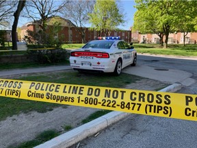 Windsor police stand guard outside the Dr. Roy Perry Apartments at 395 University Ave. E. on Wednesday.