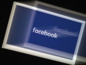 In this file photo illustration, a Facebook App logo is displayed on a smartphone in Arlington, Virginia.
