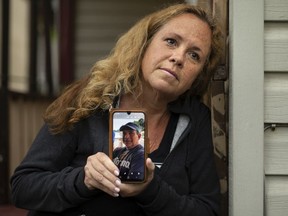 Annie Hall holds a picture of her husband, Ken Hall, on her back porch in Windsor, Monday, May 18, 2020.  Annie hasn't seen her husband, who is American, since the border closed as a result of the COVID-19 pandemic.