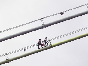 A couple of maintenance workers are shown on the Ambassador Bridge in Windsor on Wednesday, May 27, 2020.