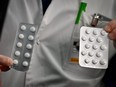 Medical staff shows packets of a Nivaquine, tablets containing chloroquine and Plaqueril, tablets containing hydroxychloroquine, drugs that has shown signs of effectiveness against coronavirus, at the IHU Mediterranee Infection Institute in Marseille, France, on Feb. 26, 2020.