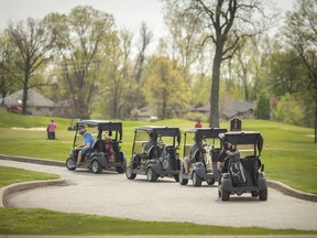 Pelee Island will allow golf carts on roads with a maximum speed of less than 50 km/h. Here, Josh Chilcoat, a backshop employee, wipes down the golf carts on the first day of golf courses being open at Ambassador Golf Club, Saturday, May 17, 2020.