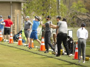Golfers work out the kinks on the driving range on the first day of golf courses being open at Ambassador Golf Club, Saturday, May 17, 2020.