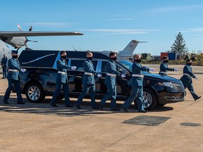 Pall bearers march past the hearse carrying RCAF Capt. Jennifer Casey during a homecoming ceremony at Halifax Stanfield International Airport in Enfield, N.S., on Sunday, May 24, 2020.