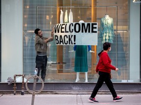 FILE PHOTO: An employee at Zara puts up a sign during a phased reopening from the coronavirus disease (COVID-19) restrictions in Toronto, Ontario, Canada May 19, 2020.