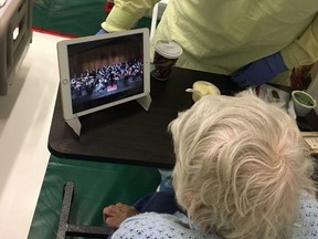 A patient at the St. Clair College field hospital watches a WSO performance for hospital patients on a recently donated iPad.     Image courtesy of Windsor Regional Hospital / Windsor Star