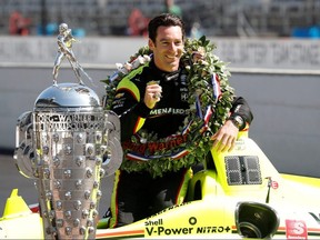 Simon Pagenaud poses with his car and the Borg Warner Trophy during a photo shoot after the Indianapolis 500 at Indianapolis Motor Speedway.
