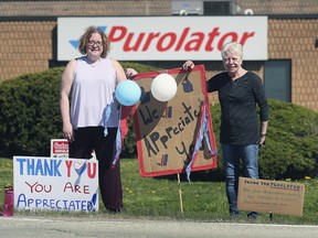 Alisa Boughner, left, and her mother Marg Boughner are shown in front of the Purolator office on the North Service Rd. in Windsor on Sunday, May 3, 2020. They decided to put up signs thanking the employees who are delivering record numbers of packages during the pandemic.