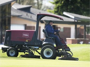 A worker cuts the grass near a green at the Roseland Golf Club in Windsor on Friday, May 1, 2020, on a mild sunny day. Premier Doug Ford announced that Ontario's marinas and golf courses could start preparing to re-open as the province begins planning for post-coronavirus.