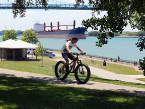 Windsor, Ontario. June 15, 2020. An unidentified cyclist rides his mountain bike along the Windsor riverfront at Askin Boulevard where a Celestrial Beacon is proposed Monday.  The beacon will house the Windsor's amazing Streetcar No. 351 if the location for the project is approved.