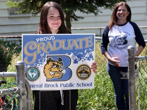 Katelynn Akins-Durocher, 13, smiles after receiving her General Brock Public School graduation lawn sign from teacher Stephanie Douglas, right, Tuesday.