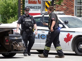 A Windsor police officer and a tow operator at the scene of a collision on Huron Church Road on June 23, 2020.