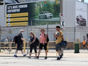 Autoworkers leave and arrive through the main gate at FCA's Windsor Assembly Plant Tuesday.