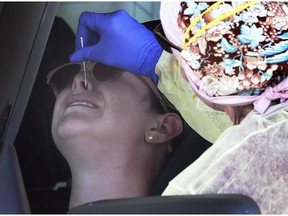 It was a busy day at the COVID-19 drive-through testing site at the Atlas Tube Centre in Lakeshore on Friday, June 12, 2020. A woman gets swabbed during the event.