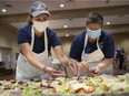 WINDSOR, ONT:. JUNE 27, 2020 -- Lisa Liovas, left, and Sherrie Koutsonicolas, prepare Greek salads for a curbside edition of the Carrousel of Nations at the Hellenic Cultural Centre, Saturday, June 27, 2020.