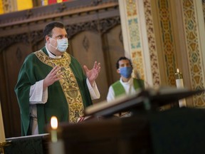 Fr. Steven Huber leads the first mass held at Our Lady of Assumption Catholic Parish since the start of the COVID-19 pandemic, Sunday, June 21, 2020.
