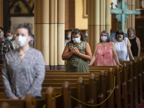 Parishioners wear masks during the first mass held at Our Lady of Assumption Catholic Parish since the start of the COVID-19 pandemic,  Sunday, June 21, 2020.