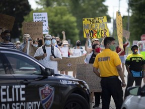 A rally  demanding better rights for migrant workers is met by security outside Lakeside Produce in Leamington on June 28, 2020.