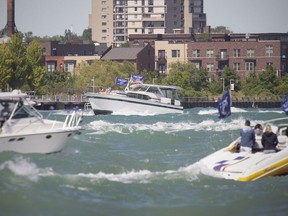 A number of boats churn up water on the Detroit River Saturday, June 13, 2020, participating in the Make America Great Again boat parade, one of a number of a number of similar events held across the U.S. to mark U.S. President Donald Trump's 74th birthday.