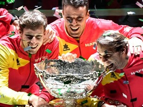 In this file photograph taken Nov. 24, 2019, Spain's Pablo Carreno, Roberto Bautista Agut and Rafael Nadal pose with the trophy after winning the final match against Canada at The Davis Cup Finals in Madrid.