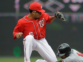 Braves baserunner Martin Prado slides safely into second base for a double as Nationals shortstop Ian Desmond bobbles the throw during MLB action at Nationals Park in Washington, D.C., April 3, 2011.