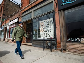 A closed store front boutique business pleads for help on a sign in Toronto in April.