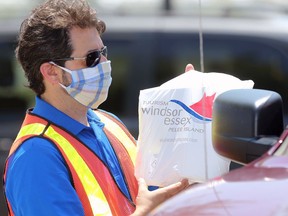 Kingsville Mayor Nelson Santos delivers hand sanitizer to an area business owner at the Kingsville Arena Tuesday. The City of Windsor provided free hand sanitizer to businesses and non-profits in Leamington and Kingsville.