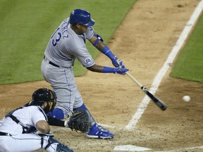 Salvador Perez of the Kansas City Royals hits into a fielders choice that scores Whit Merrifield, with catcher Austin Romine of the Detroit Tigers behind the plate, during the seventh inning at Comerica Park on July 30, 2020, in Detroit, Michigan. The Royals defeated the Tigers 5-3.