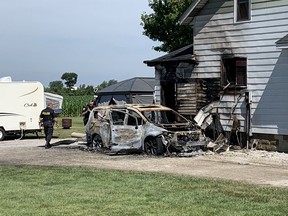 OPP officers investigate on Saturday, July 18, 2020, following a fire at a home in the 7000 block of County Rd. 23, also known as Arner Townline, in Essex. A van at the scene was destroyed and the home was damaged by fire.