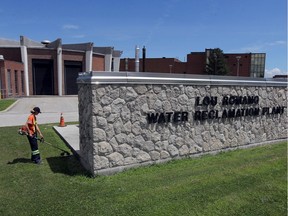 A worker trims the front lawn at the Lou Romano Water Reclamation Plant on Friday, July 31, 2020.