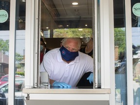 Ontario Premier Doug Ford stands at a window used for take-outs, as he visits a bakery in Toronto, on Friday, July 10, 2020.