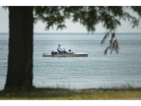 A lone fisherman cruises along the shoreline of Lake St. Clair on a hot Thursday afternoon, July 9, 2020.