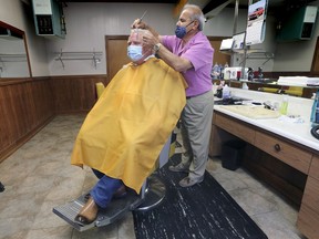 Ontario Premier Doug Ford gets his hair cut by Henry Mastronardi at a Leamington barbershop on Thursday, July 16, 2020.