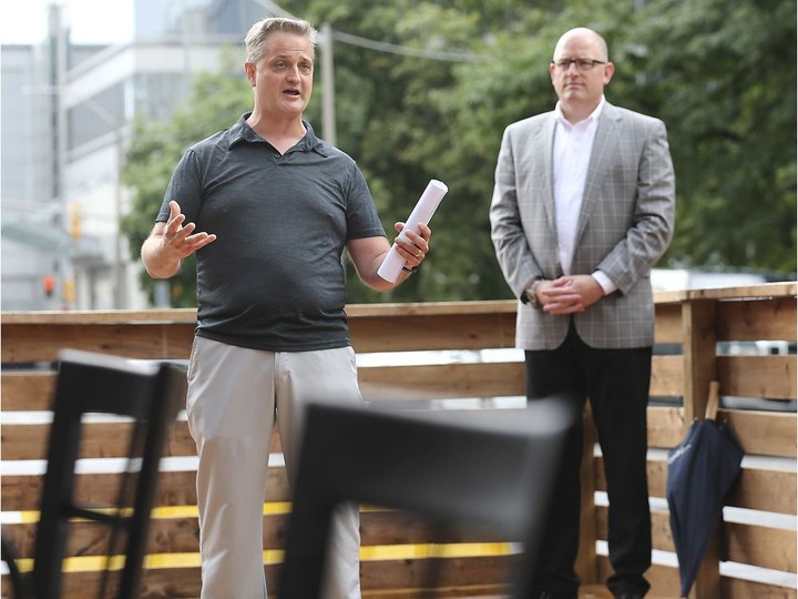  In this file photo from July 2020, Downtown Windsor Business Improvement Association chairman Brian Yeomans, left, and Mayor Drew Dilkens took part in the unveiling of a “Pitt Street Parklet” in downtown Windsor that offered outdoor seating for patrons of three neighbouring restaurants.