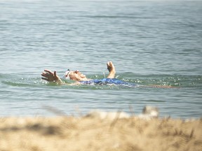 A woman swims at the East Beach of Sand Point Beach Park, Thursday, July 9, 2020.
