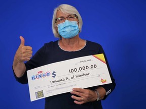Windsor resident Dusanka Andjelkovic (responsibly wearing a face mask) shows the $100,000 cheque she won from an Instant Bingo Doubler scratch game.