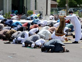 Eid Mubarak. A worshipper gently places his prayer mat to join dozens of other worshippers for special prayer on the holy day of Eid al-Adha at Windsor Mosque on Dominion Boulevard on Friday, July 31, 2020.