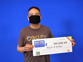 Roy Macatangay, 47, of Windsor, with his prize cheque from playing ENCORE on a Lotto MAX ticket in May 2020.