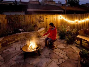 A woman enjoys a backyard fire pit in Toronto in this 2009 National Post file photo.