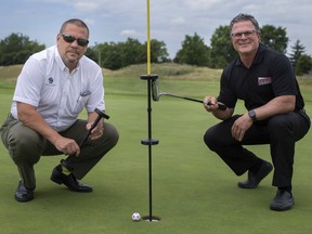Frank Cirino and David Thibert, left, are pictured with their Mully Cup flag stick invention that allows golfers to avoid touching the flag stick, while at Pointe West Golf Club, Tuesday, July 21, 2020.