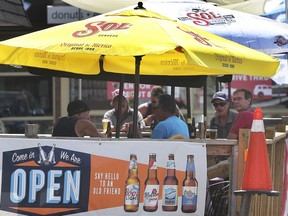 Patrons are shown at an outdoor patio at the Lion's Head Tavern in Windsor on Tuesday, July 28, 2020. Health authorities are warning people to continue to remain cautious and maintain safe practices as the economy gradually reopens.