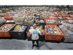 Joshua Lane, one of the organizers of the June 27th Miracle stands in a community rink at the WFCU Centre on Tuesday, July 7, 2020. The massive pile of food is just a portion of the two million pounds collected during the event.