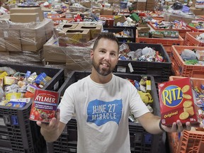 Joshua Lane, one of the organizers of the June 27th Miracle stands in a community rink at the WFCU Centre on Tuesday, July 7, 2020. The massive pile of food is just a portion of the two million pounds collected during the event.