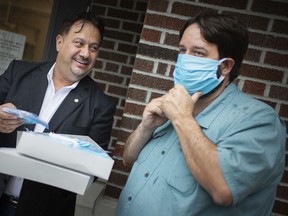Executive director of the Downtown Mission, Ron Dunn, right, tries on a mask donated by Khassan Saka, executive director of the Windsor-based Iraqi Canadian Group Organization, Friday, July 10, 2020.  The group donated more than 1000 custom-made masks to the mission.