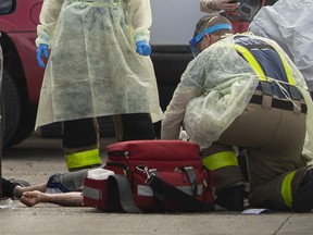 EMS paramedics and Windsor firefighters works on a male patient suspected of having an overdose from fentanyl as he lies on the pavement outside Rally Auto Service on the corner of Marentette Avenue and Tecumseh Road East, Thursday, May 28, 2020.