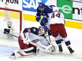 Joonas Korpisalo of the Columbus Blue Jackets stops a shot as Leafs' Auston Matthews is kept out of harm's way by defenceman Vladislav Gavrikov during the second period of Game 1 last night at Scotiabank Arena.